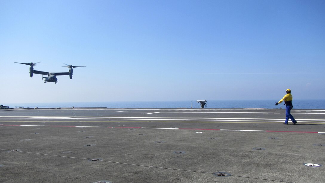 A French sailor signals to the pilots of an MV-22B Osprey helicopter, assigned to Marine Medium Tiltrotor Squadron 263, Special Purpose Marine Air-Ground Task Force-Crisis Response-Africa, as it prepares to land on the flight deck of the French aircraft carrier Charles de Gaulle, in the Mediterranean Sea, July 6, 2016. This training allowed U.S. Marines and French sailors to practice deck procedures including tie-downs, taxiing and refueling the aircraft.