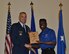 Keynote speaker Maj. Gen. Bradley D. Spacy, director of mission support for the Air Force Installation and Mission Support Center, presents Dorian Holmes his award. Holmes, repesenting Joint Base Charleston, South Carolina, was co-master of the awards ceremony. (U.S. Air Force photo/Carole Chiles Fuller/released)