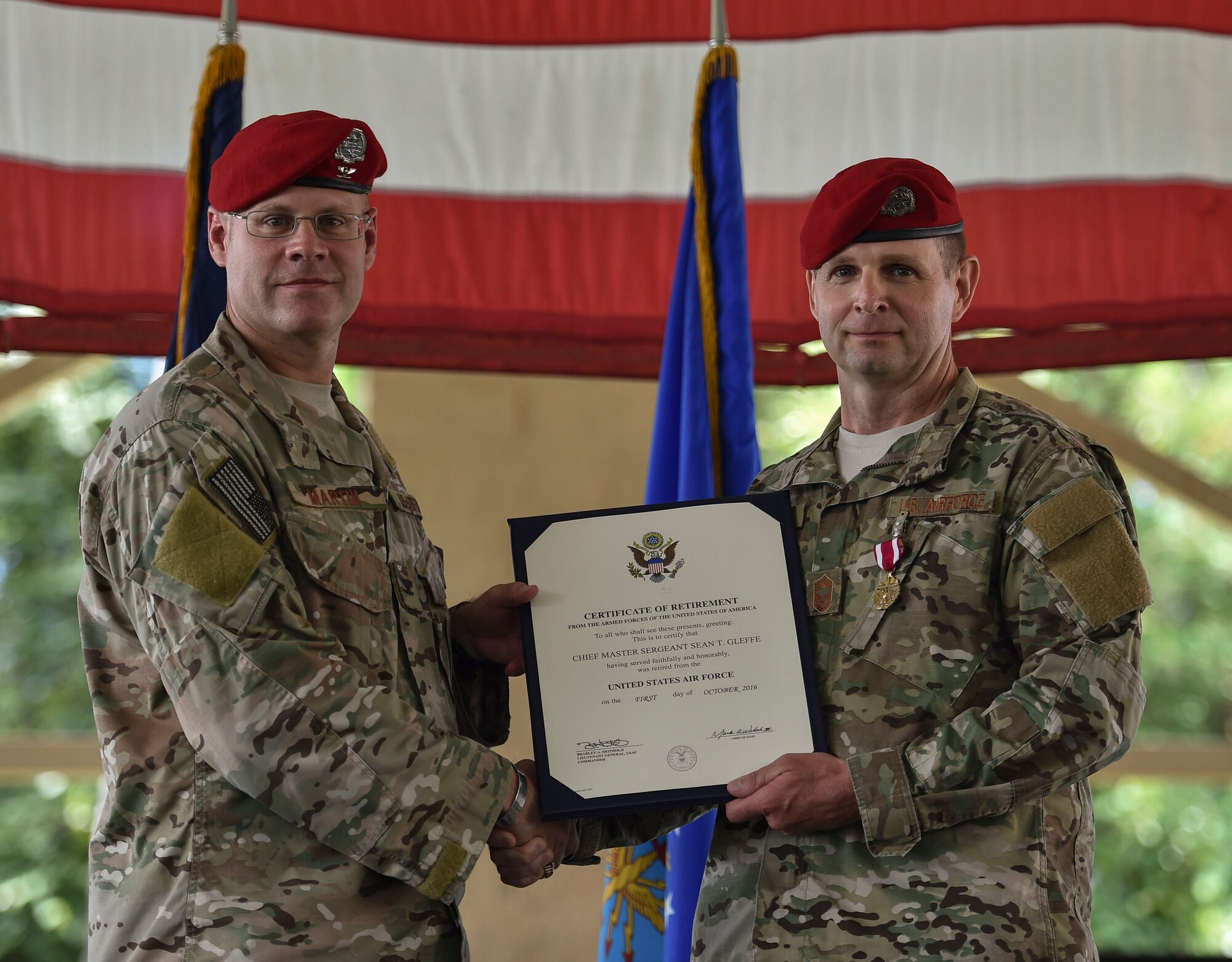 (From left) Col. Michael Martin, commander of the 24th Special Operations Wing, presents Chief Master Sgt. Sean Gleffe, combat control functional manager of Air Force Special Operations Command, a retirement certificate at Hurlburt Field, Fla., July 15, 2016. Gleffe retired following 30 years as a combat controller. Gleffe also served as the interim command chief of the 24th SOW. Throughout his Special Tactics career, Gleffe was certified a static line jump master, military freefall jump master and military dive supervisor. (U.S. Air Force photo by Senior Airman Ryan Conroy)