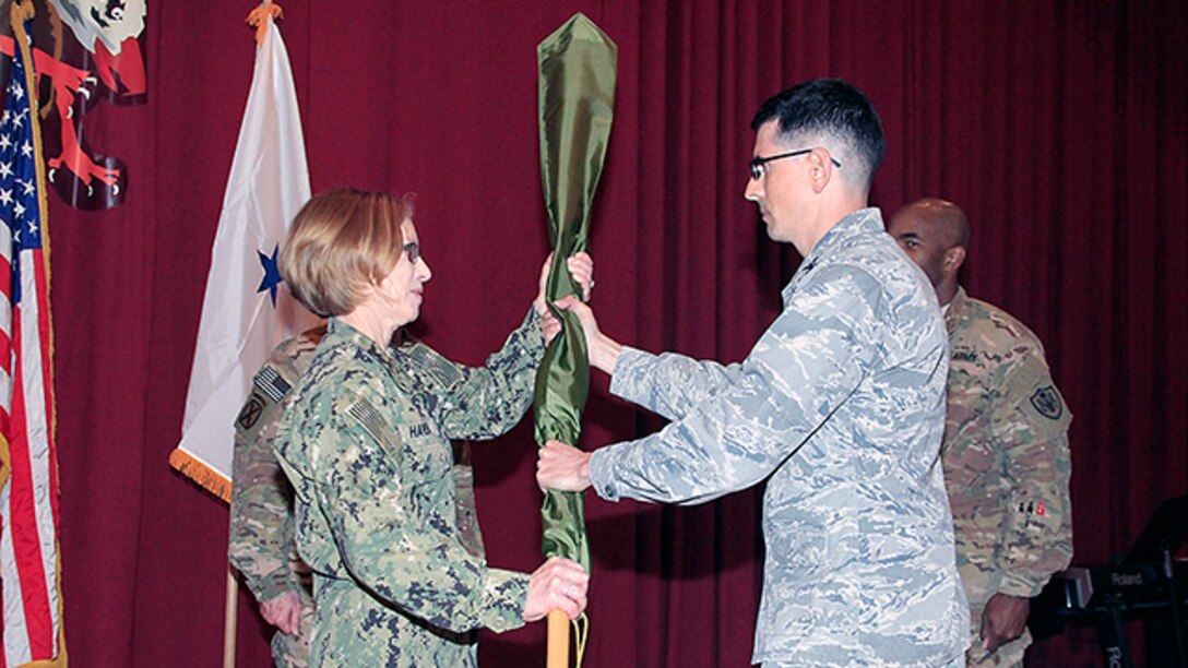 Air Force Col. Christopher Juarez, Defense Contract Management Agency Middle East commander, presents the cased colors of DCMA Afghanistan to Navy Rear Adm. Deborah Haven, DCMA International commander, during a casing ceremony marking the end of DCMA's mission in Afghanistan at Camp Arifjan, Kuwait, Jan. 14. 
