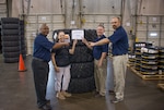 SAIC staff in the Fort Worth, Texas warehouse celebrating the Millionth tire delivered. (from left to right) Jeff Wynn, Lisa Miller, David Dahman and Brad Weaver.  Photo courtesy of SAIC.  