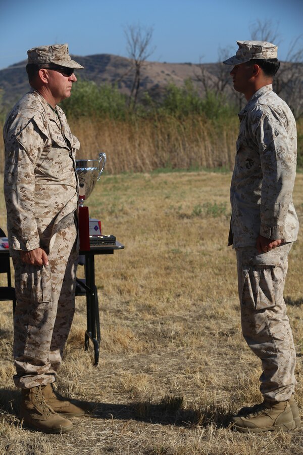 Chief Warrant Officer 5 Vincent Kyzer, the 1st Marine Division Gunner, and Lance Cpl. Kalin Mamales, a rifleman with Co. A, 3rd Light Armored Reconnaissance Battalion, 1st Marine Division stand at the position of attention as Mamales is presented a Certificate of Commendation for placing second in the infantry marksmanship competition during the 2016 1st Marine Division Squad Competition award ceremony at Camp Pendleton, Calif., July 14, 2016. The 1st Marine Division hosted its annual Infantry Squad or “Super Squad” competition which pits the 1st, 5th, and 7th Marine Regiments and a Light Armored Reconnaissance Battalions against each other in tests designed to evaluate their leadership and small unit, infantry skills. (U.S. Marine Corps photo by Lance Cpl. Shellie Hall)