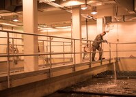 U.S. Air Force Airman 1st Class Troy Moncrief, a 354th Civil Engineering Squadron wastewater apprentice, displays solids removed from sewage after he removed it from a trap underground at the Eielson Air Force Base, Alaska, wastewater treatment plant July 14, 2016. Anything that cant be treated by aeration, bacteria or chemicals is removed prior to entering settling tanks and ponds. (U.S. Air Force photo by Staff Sgt. Shawn Nickel)
