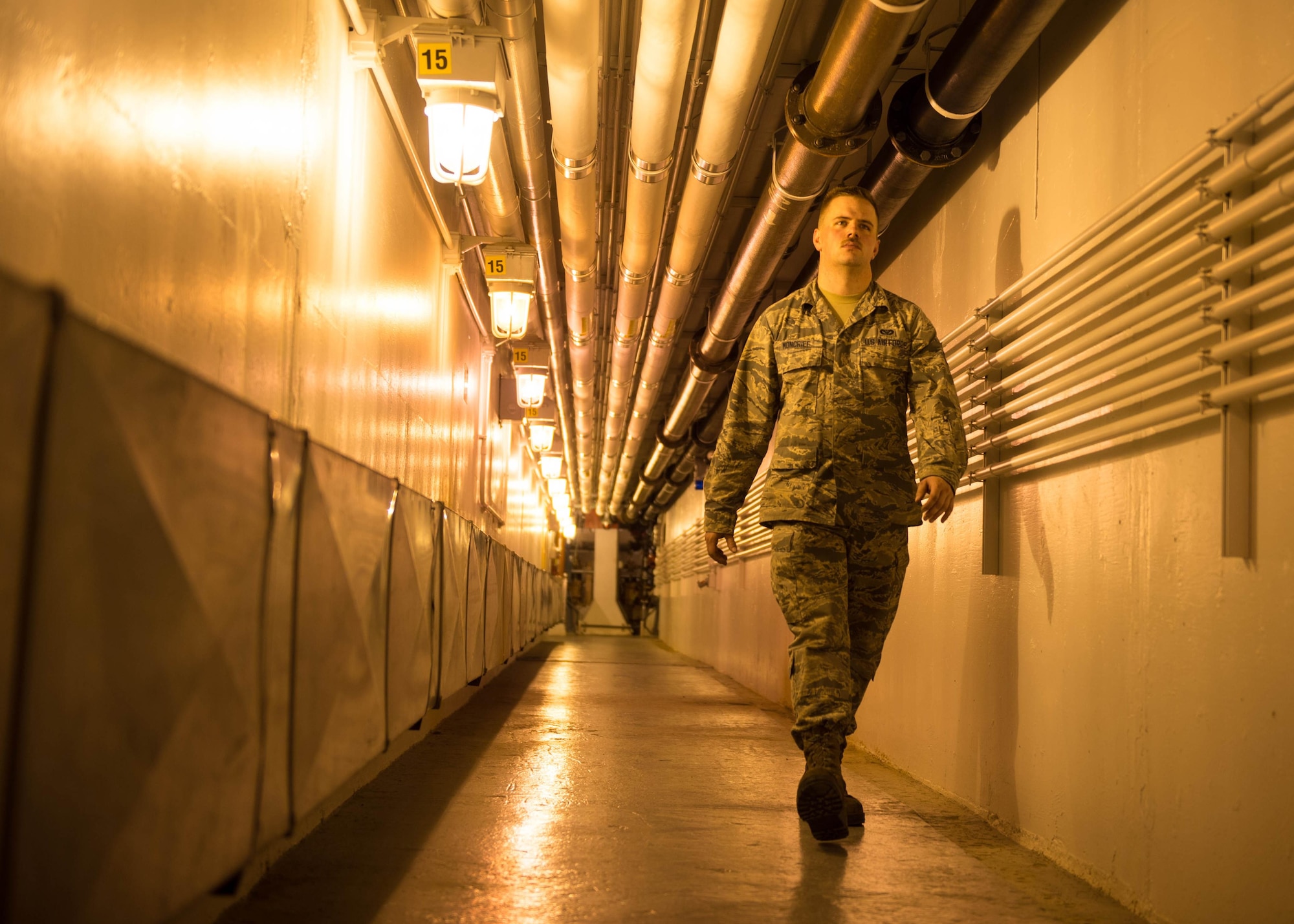 U.S. Air Force Airman 1st Class Troy Moncrief, a 354th Civil Engineering Squadron wastewater apprentice, walks down the hall of the Eielson Air Force Base, Alaska, wastewater treatment plant July 14, 2016. Moncrief compares the underground portion of the plant to a submarine with its low hanging pipes, ladders, and tight spaces. (U.S. Air Force photo by Staff Sgt. Shawn Nickel)
