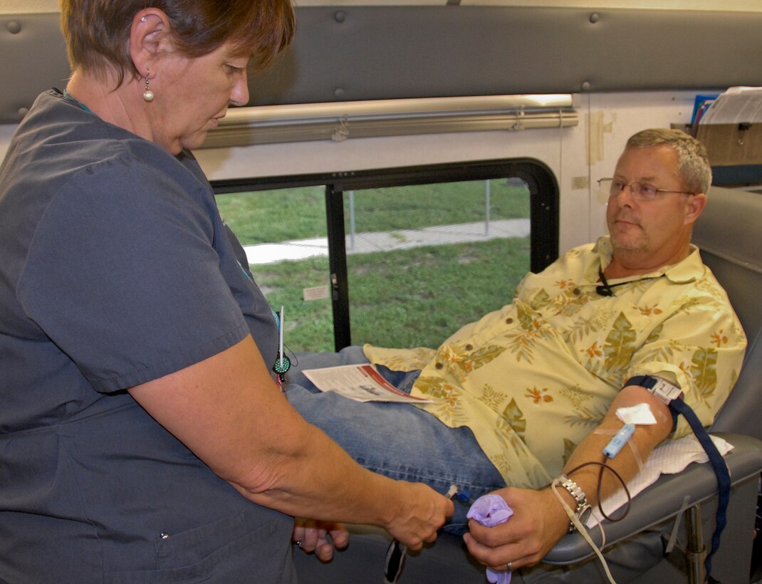 Suzy DeBlanc, One Blood Drive bloodmobile team member, monitors the donation process as Brad Bien, a 96th Test Wing safety specialist, gives blood July 19 at Eglin Air Force Base, Fla.  All donors received wellness checkups, which included iron count; blood pressure; temperature check and cholesterol screenings.  (U.S. Air Force photo/Kevin Gaddie)