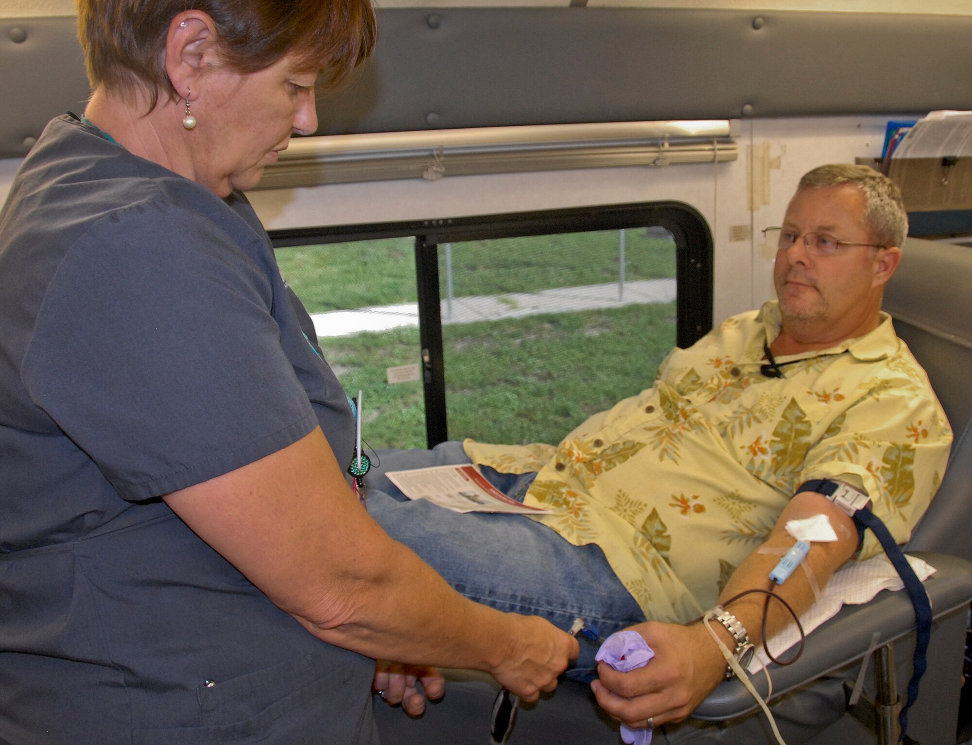 Suzy DeBlanc, One Blood Drive bloodmobile team member, monitors the donation process as Brad Bien, a 96th Test Wing safety specialist, gives blood July 19 at Eglin Air Force Base, Fla.  All donors received wellness checkups, which included iron count; blood pressure; temperature check and cholesterol screenings.  (U.S. Air Force photo/Kevin Gaddie)