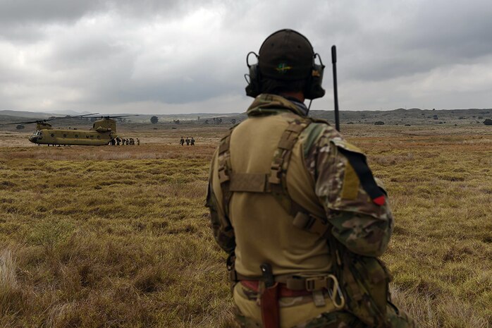 A combat controller with the 320th Special Tactics Squadron watches as Army Special Forces and Marine Raiders board a CH-47 Chinook after a multi-aircraft, joint airborne operation with special operations assets and conventional forces from all four branches of the U.S. Armed Forces as part of Rim of the Pacific 2016 to strengthen their relationships and interoperability with their partners, Pohakuloa Training Area, Hawaii, July 14, 2016. Twenty-six nations, more than 40 ships and submarines, more than 200 aircraft and 25,000 personnel are participating in RIMPAC from June 30 to Aug. 4, in and around the Hawaiian Islands and Southern California. The world's largest international maritime exercise, RIMPAC provides a unique training opportunity that helps participants foster and sustain the cooperative relationships that are critical to ensuring the safety of sea lanes and security on the world's oceans. RIMPAC 2016 is the 25th exercise in the series that began in 1971. 