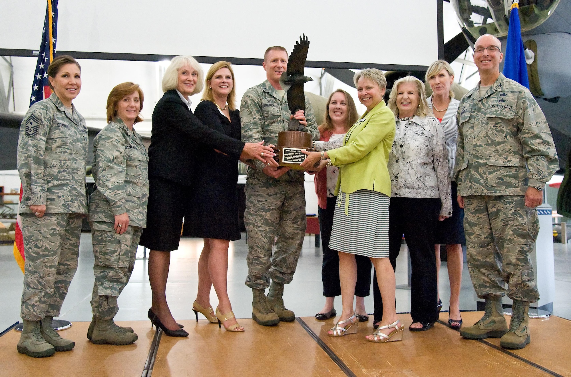 Col. Michael W. Grismer Jr., 436th Airlift Wing commander, and Judy Diogo, Central Delaware Chamber of Commerce president, hold the 2015 Abilene Trophy during the presentation ceremony July 13, 2016, at the Air Mobility Command Museum on Dover Air Force Base, Del. The Abilene Trophy, previously known as the Air Mobility Community Support Award which was established in 1998, is awarded annually to a civilian community for outstanding support to a nearby Air Mobility Command base. Pictured on stage with Grismer and Diogo were representatives of the 436th and 512th Airlift Wings, Air Force Mortuary Affairs Operations, Abilene Chamber of Commerce and the CDCC. (U.S. Air Force photo/Roland Balik) 