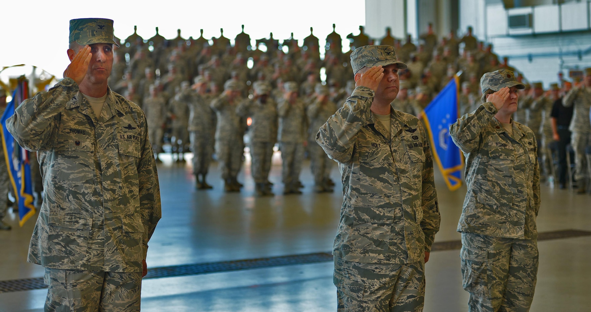 Col. Anthony Thomas, Air Force Special Operations Command director of cyber and command, control, communications and computer systems; Col. William Holt, AFSOC director of operations; and Maj. Lisa Stokey, executive officer to the AFSOC vice commander, lead the formation of Air Commandos at the change of command ceremony, July 19, 2016, held in Freedom Hangar.  (U.S. Air Force photo by Staff Sgt. Melanie Holochwost)