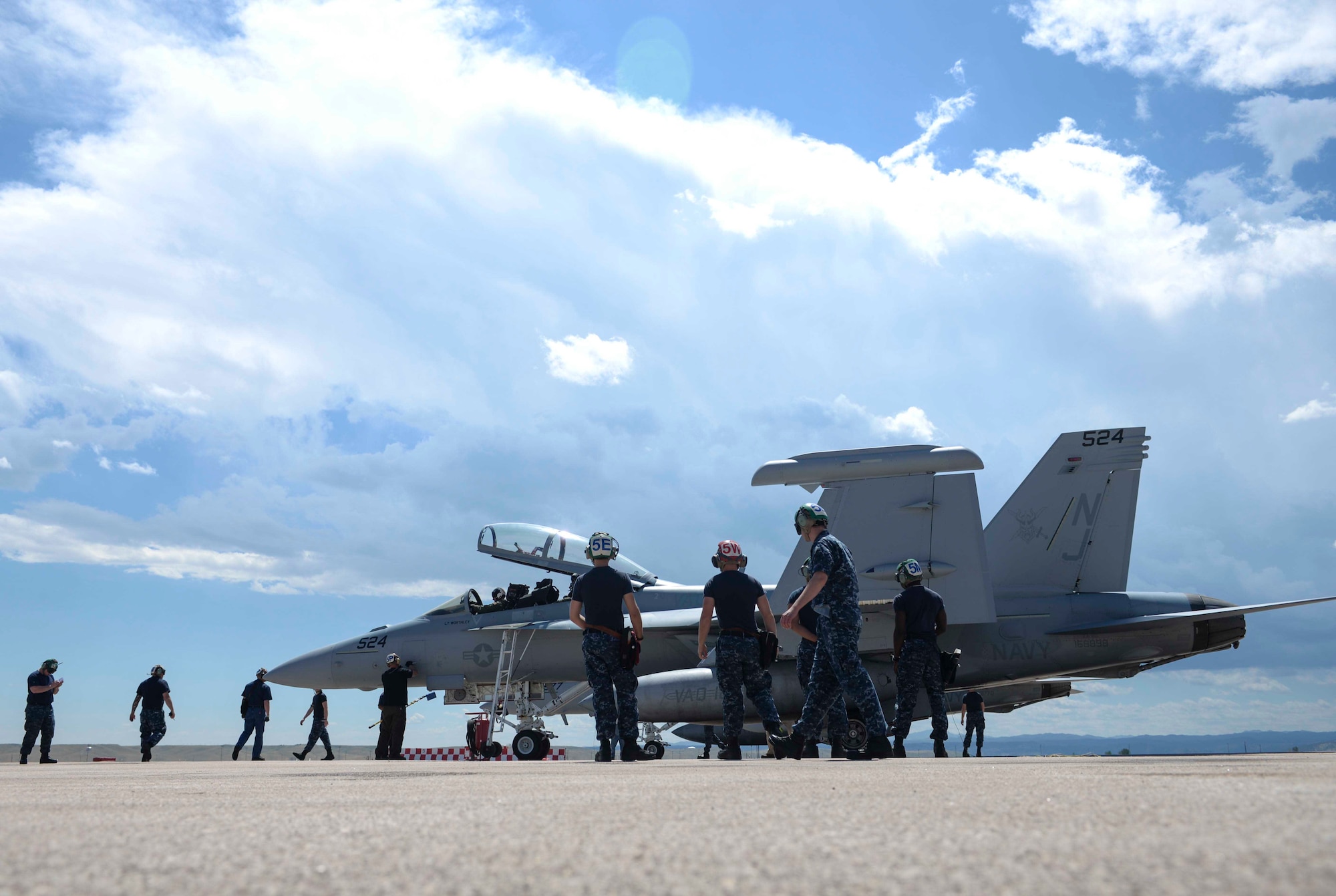 Navy maintenance personnel from Electronic Attack Squadron (VAQ) 129, assigned to Naval Air Station Whidbey Island, Wash., conduct a preflight check on an EA-18G Growler before a training flight at Ellsworth Air Force Base, S.D., July 15, 2016. Approximately 110 Sailors participated in the training, maintaining six EA-18G Growlers and focusing on airborne electronic attack tactics. (U.S. Air Force photo by Airman 1st Class Sadie Colbert/Released)