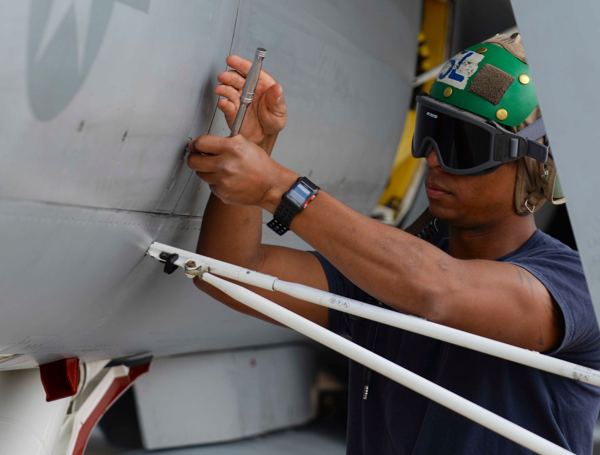 Navy Aviation Structural Mechanic (Safety Equipmentman) Third Class J.P. Sharp, assigned to Electronic Attack Squadron (VAQ) 129, secures panels for a preflight check during training at Ellsworth Air Force Base, S.D., July 15, 2016. Approximately 110 Sailors participated in the training, performing tasks such as turnarounds which require personnel to check for gear damage as well as prepare the jet for another take-off. (U.S. Air Force photo by Airman 1st Class Sadie Colbert/Released)