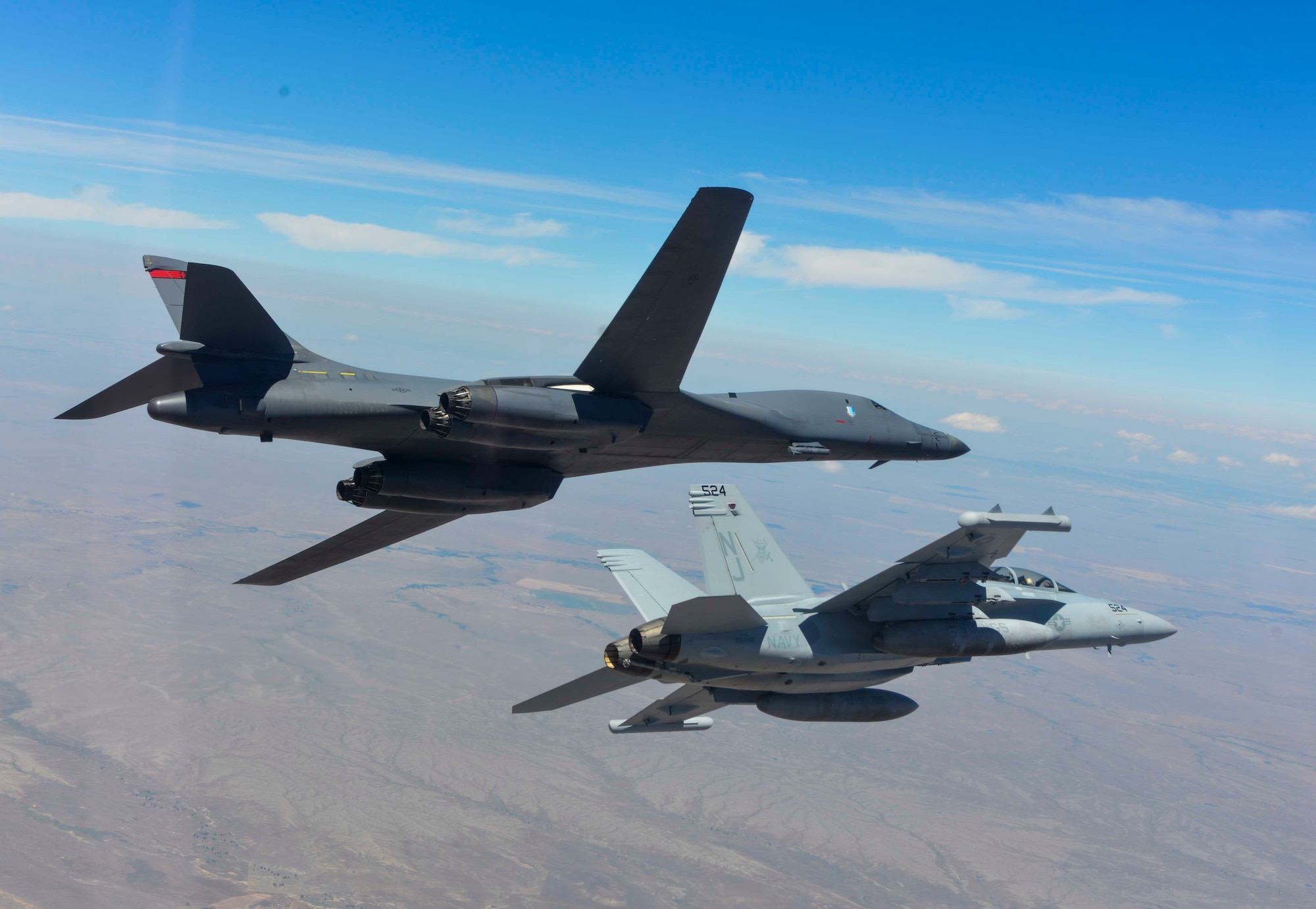 A B-1 bomber and EA-18G Growler bank to the left during a training sortie near Ellsworth Air Force Base, S.D., July 15, 2016. The training focused on further improving joint mission tactics between Air Force and Naval forces. (Courtesy Photo/Released)