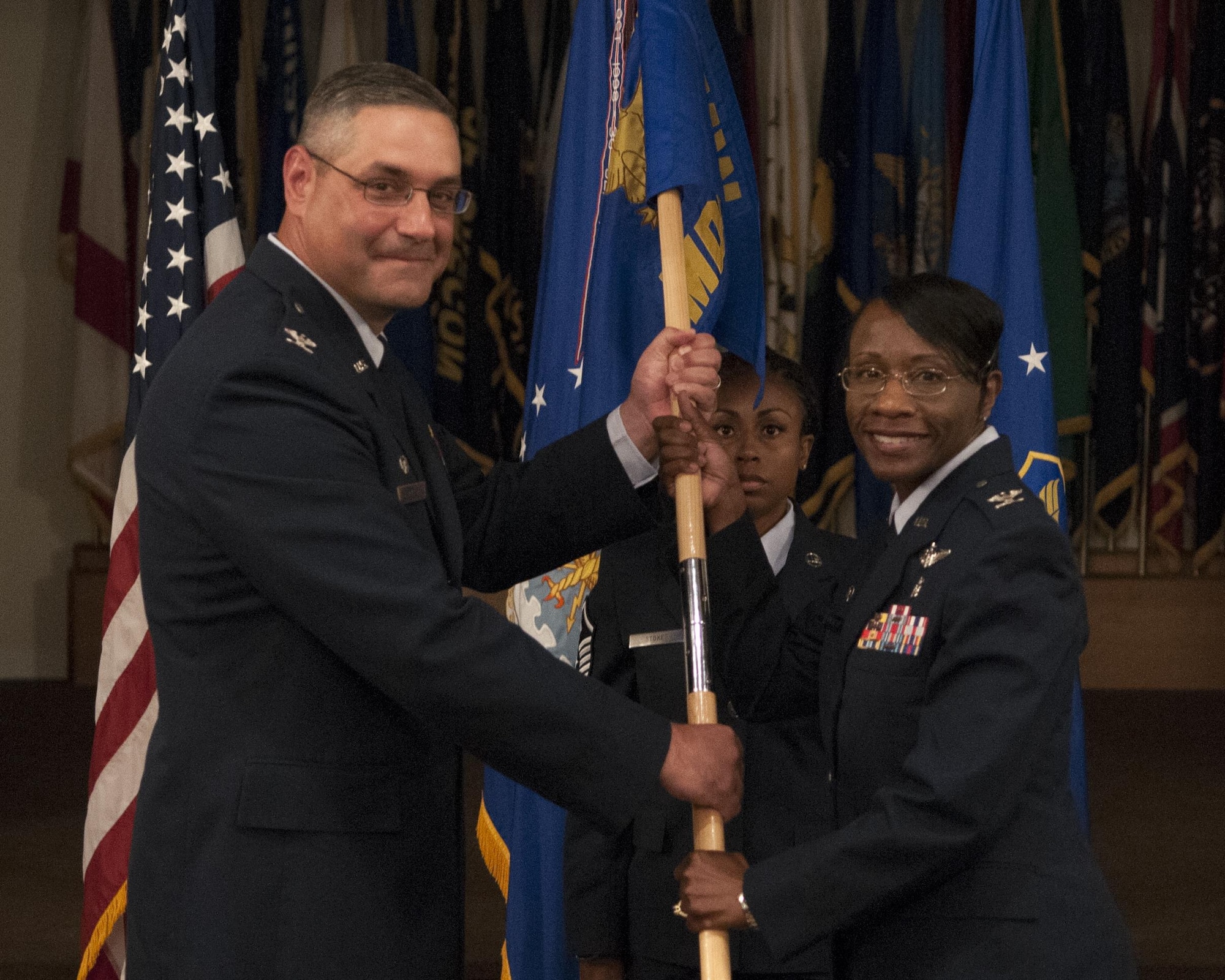 Col. Cherron Galluzzo, 90th Medical Group commander, takes the MDG guidon from Col. Stephen Kravitsky, 90th Missile Wing commander, during an assumption-of-command ceremony July 19, 2016, at F.E. Warren Air Force Base, Wyo. The passing of the guidon stems from military tradition, with guidon symbolizing a flag that soldiers would rally behind during battles. (U.S. Air Force photo by Airman 1st Class Malcolm Mayfield)