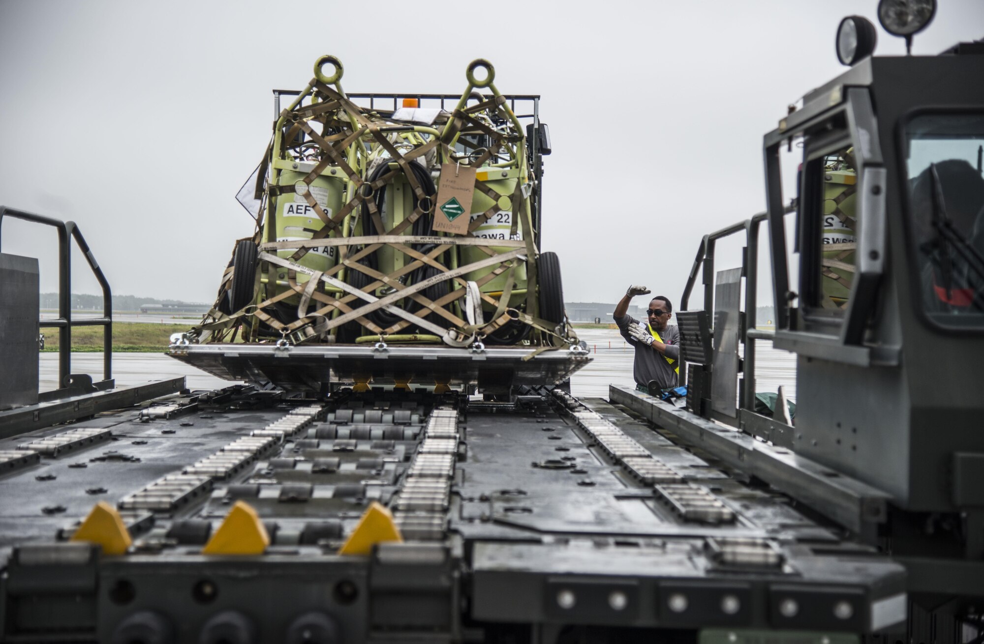 A loadcrew member directs an Airman operating a k-loader at Misawa Air Base, Japan, July 17, 2016. Airmen from the 35th Logistics Readiness Squadron loaded more than 461,000 pounds of cargo destined for Exercise Pitch Black in Australia. Exercise Pitch Black enhances the partnerships of the participing nations and places high value on regional security and fostering closer ties throughout the Indo-Asia-Pacific region. (U.S. Air Force photo by Senior Airman Brittany A. Chase)