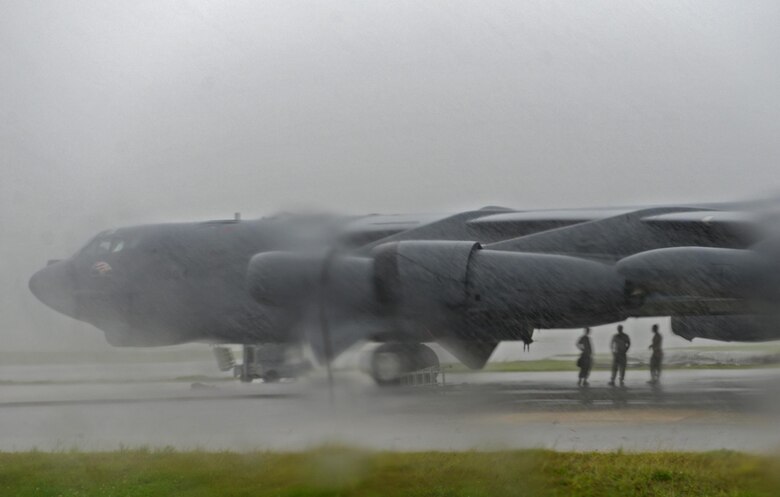 Airmen assigned to the 36th Expeditionary Aircraft Maintenance Squadron take shelter under a B-52H Stratofortress prior to the start of a munitions loading exercise July 13, 2016, at Andersen Air Force Base, Guam. During the exercise, Airmen practiced loading inert munitions including, AGM-86 Conventional Air-Launched Cruise Missiles and AGM-158 Joint Air-to-Surface Standoff Missiles. (U.S. Air Force photo by Airman 1st Class Alexa Ann Henderson/Released)