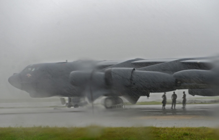 Airmen assigned to the 36th Expeditionary Aircraft Maintenance Squadron take shelter under a B-52H Stratofortress prior to the start of a munitions loading exercise July 13, 2016, at Andersen Air Force Base, Guam. During the exercise, Airmen practiced loading inert munitions including, AGM-86 Conventional Air-Launched Cruise Missiles and AGM-158 Joint Air-to-Surface Standoff Missiles. (U.S. Air Force photo by Airman 1st Class Alexa Ann Henderson/Released)