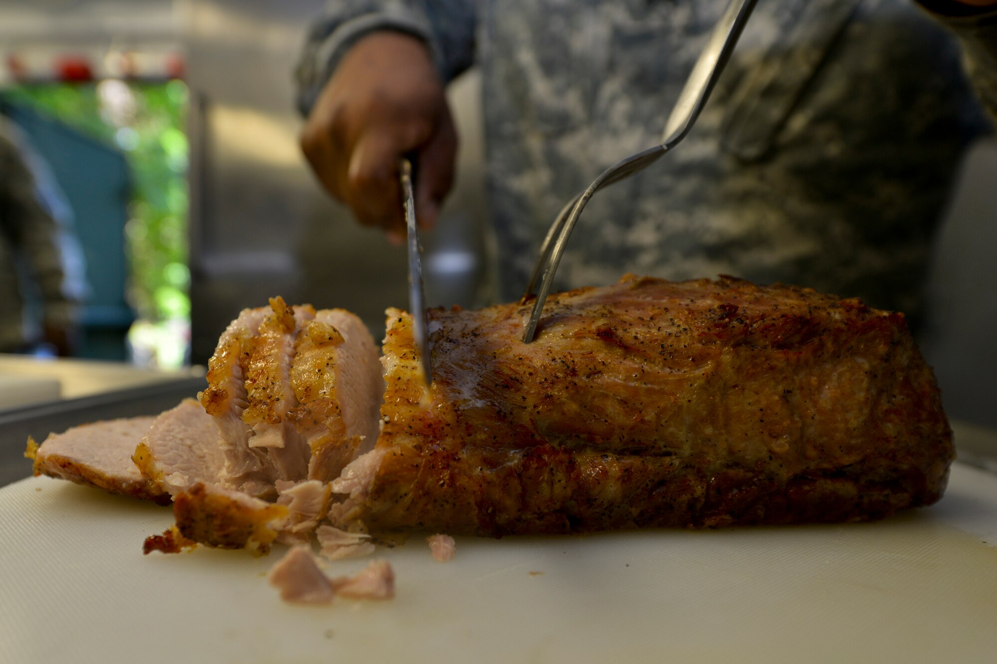 A U.S. Army Reserve Soldier with the Echo Company, 5th Battalion, 159th General Support Aviation Brigade, slices a pork roast as part of a practice meal for the Philip A. Connely Culinary Field Competition at Fort Eustis, Va., July 13, 2016.  The competition judges both in garrison and field culinary operations. (U.S. Air Force photo by Staff Sgt. Natasha Stannard)