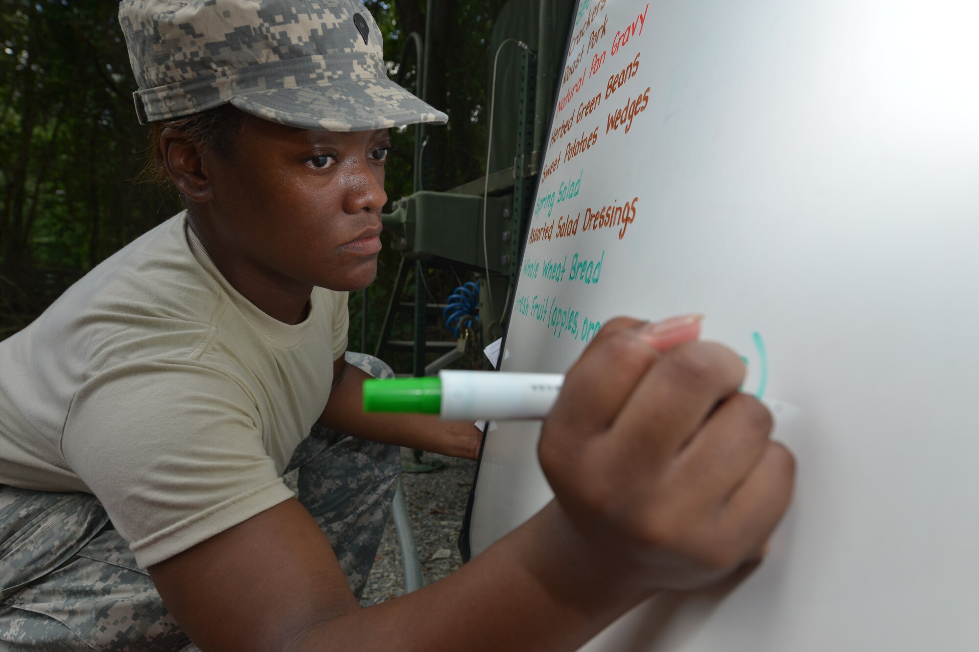 U.S. Army Spc. Montara Jennings, Echo Company, 5th Battalion, 159th General Support Aviation Brigade nutrition specialist and cook, writes the menu for a training meal in preparation for the Philip A. Connely Culinary Field Competition at Fort Eustis, Va., July 13, 2016.  Jennings color coded the menu to identify the most nutritious items available. (U.S. Air Force photo by Staff Sgt. Natasha Stannard)
