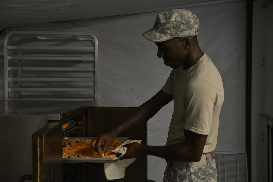 U.S. Army Spc. David Palmer, Echo Company, 5th Battalion, 159th General Support Aviation Brigade cook, checks the tenderness of sweet potato wedges during a training meal for the Philip A. Connely Culinary Field Competition at Fort Eustis, Va., July 13, 2016. The Army wide food service competition aims to improve the professionalism of food service personnel as a means to provide high quality meals to Soldiers in the field. (U.S. Air Force photo by Staff Sgt. Natasha Stannard)

