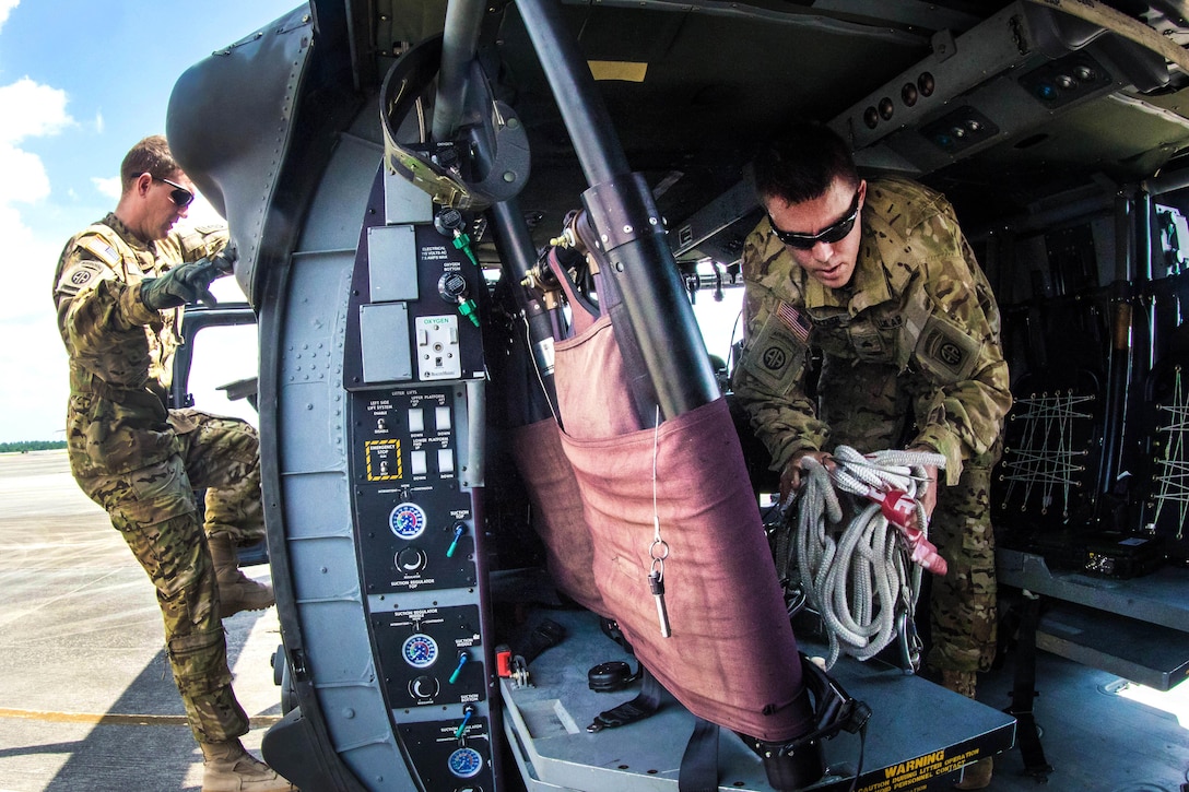 Two soldiers conduct a preflight inspection on a UH-60 Black Hawk helicopter before participating in a routine flight over Fort Bragg, N.C., July 12, 2016. Army photo by Capt. Adan Cazarez