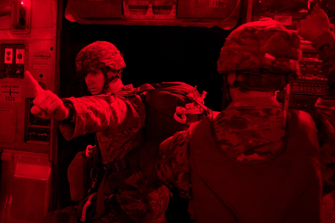 A paratrooper gives the one-minute signal before jumping over Sicily drop zone during Battalion Mass Tactical Week at Pope Army Airfield, N.C., July 12, 2016. The paratrooper is assigned to the 82nd Airborne Division. Air Force photo by Staff Sgt. Sandra Welch