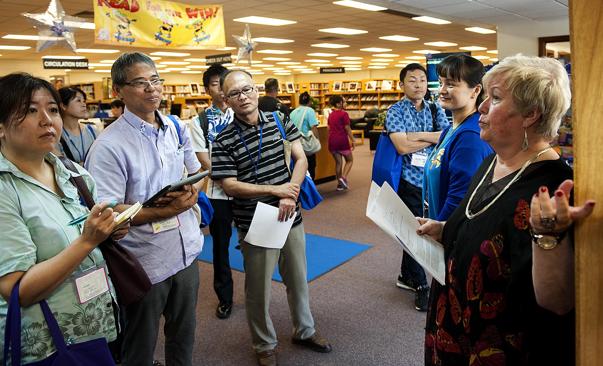 Belinda Pugh, 18th Force Support Squadron resource librarian, explains a display during a tour of the library to local Okinawan librarians July 13, 2016, at Kadena Air Base, Japan. The purpose of the tour was for local Okinawan librarians to familiarize themselves with American culture so they can set up an “American corner” in their libraries. (U.S. Air Force photo by Airman 1st Class Corey M. Pettis)