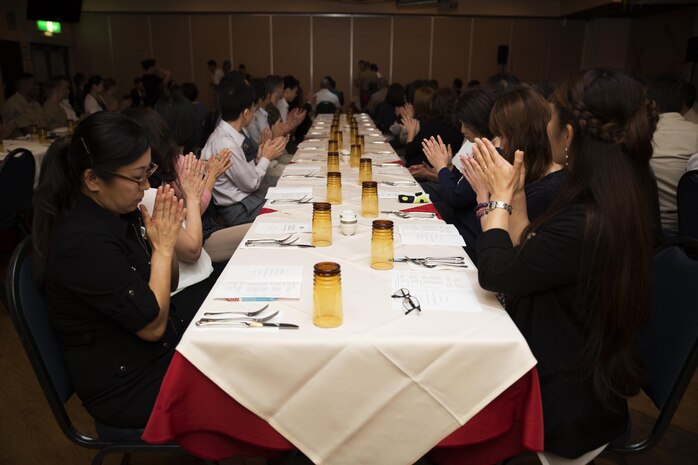 Guests attending a retirement ceremony at the Landing Zone inside Club Iwakuni at Marine Corps Air Station Iwakuni, Japan, applaud as Master Labor Contract and Indirect Hire Agreement employees receive certificates of appreciation July 15, 2016. The ceremony acknowledged the appreciation of the retirees’ hard work over the years. (U.S. Marine Corps photo by Lance Cpl. Joseph Abrego)  

