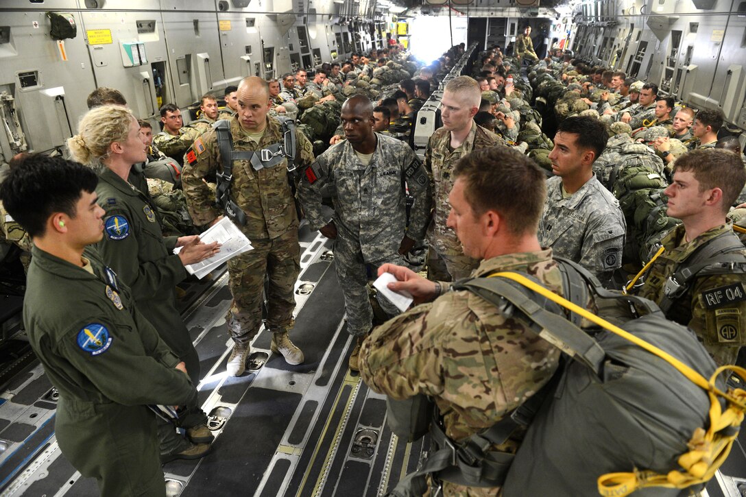 Air Force Capt. Anne Marie Kemp, second from left, briefs paratroopers before participating in a static-line airborne operation over Sicily drop zone during Battalion Mass Tactical Week at Pope Army Airfield, N.C., July 12, 2016. Air Force photo by Staff Sgt. Sandra Welch