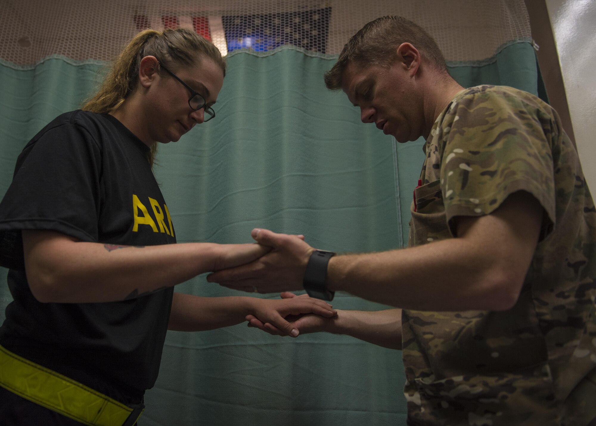 Maj. Brandon Morgan (right), 455th Expeditionary Medical Group physical therapist, instructs U.S. Army Specialist Michelle Kempker (left), Bravo 2-44 counter rocket, artillery, and mortar operator to, raise up on her toes during a patient evaluation, Bagram, Afghanistan, July 19, 2016. Morgan helps patients reduce pain and improve or restore mobility. (U.S. Air Force photo by Senior Airman Justyn M. Freeman)