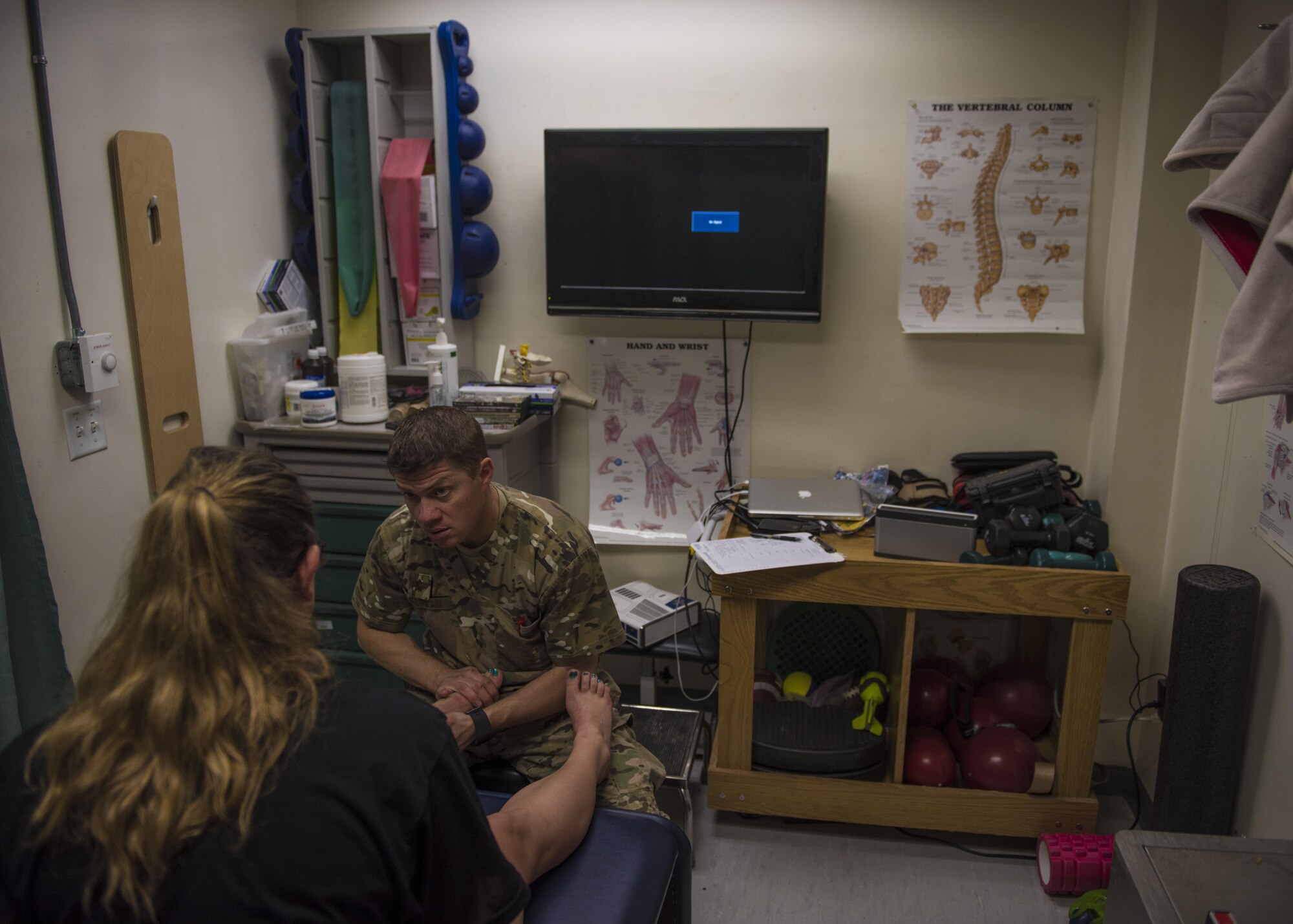 Maj. Brandon Morgan, 455th Expeditionary Medical Group physical therapist, conducts a patient evaluation on U.S. Army Specialist Michelle Kempker, Bravo 2-44 counter rocket, artillery, and mortar operator, Bagram, Afghanistan, July 19, 2016. Morgan, as a physical therapist, helps patients to recover from injuries so they are able to return to duty in a healthy state. (U.S. Air Force photo by Senior Airman Justyn M. Freeman)