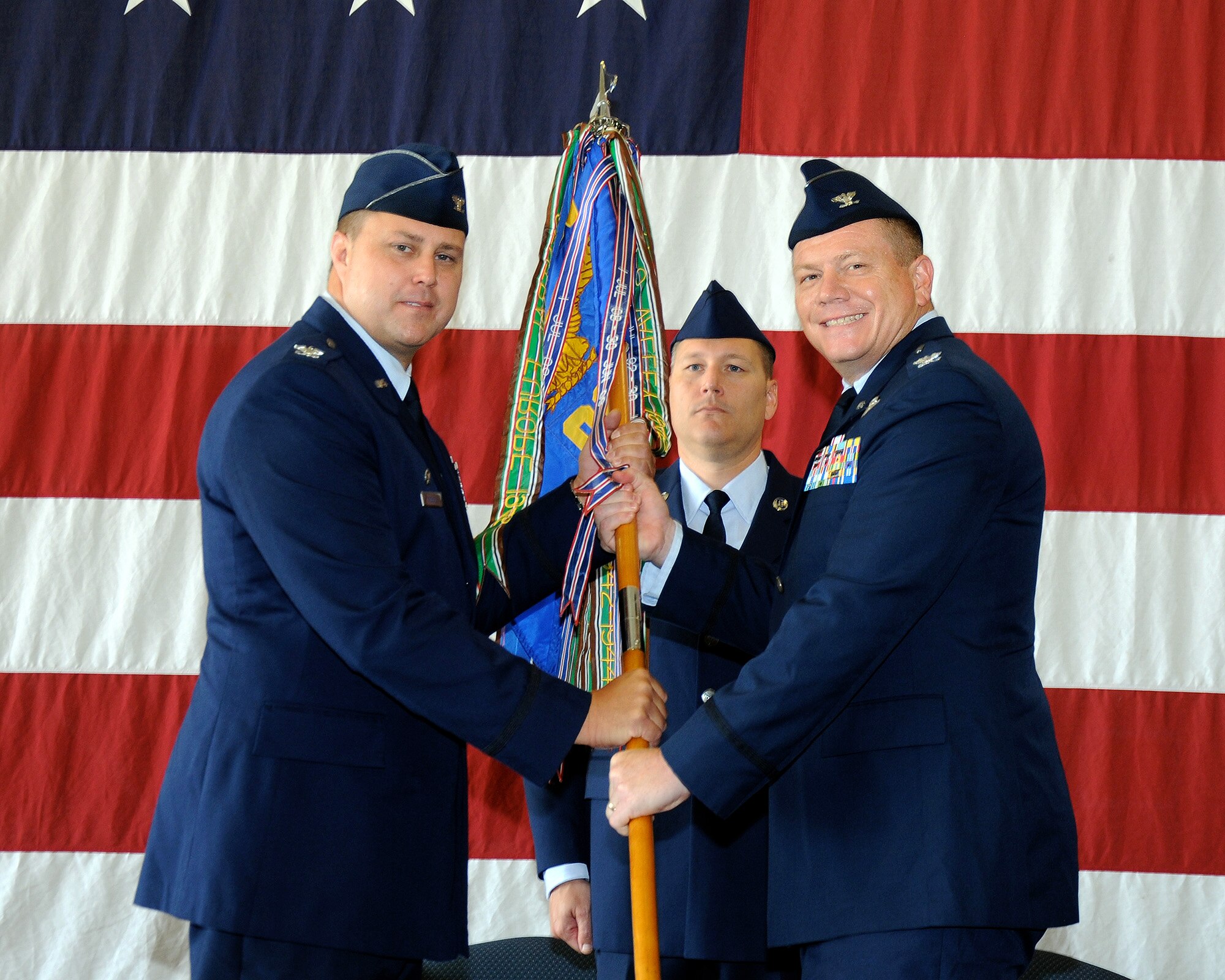 Col. John Nichols, 14th Flying Training Wing Commander, passes the 14th Operations Group guidon to Col. Stan Lawrie, the new 14th OG Commander, during a change of command ceremony July 15 at Columbus Air Force Base, Mississippi. (U.S. Air Force photo/Sharon Ybarra)