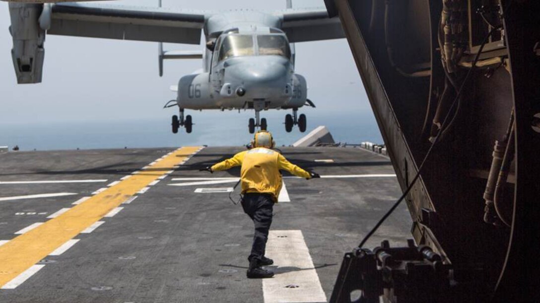 An aviation boatswain’s mate guides an MV-22 Osprey from VMM-363, Special Purpose Marine Air Ground Task Force-Crisis Response-Central Command, to land on the deck of the amphibious assault ship USS Boxer, July 7, 2016. The 13th Marine Expeditionary Unit hosted flight deck landing qualifications for SPMAGTF-CR-CC V-22's, demonstrating interoperability between Navy and Marine Corps units . The Boxer is currently in support of the 13th Marine Expeditionary Unit operating in and around the Central Command area of responsibility.  SPMAGTF-CR-CC is forward deployed in several host nations, with the ability to respond, rapidly, to a variety of contingencies.