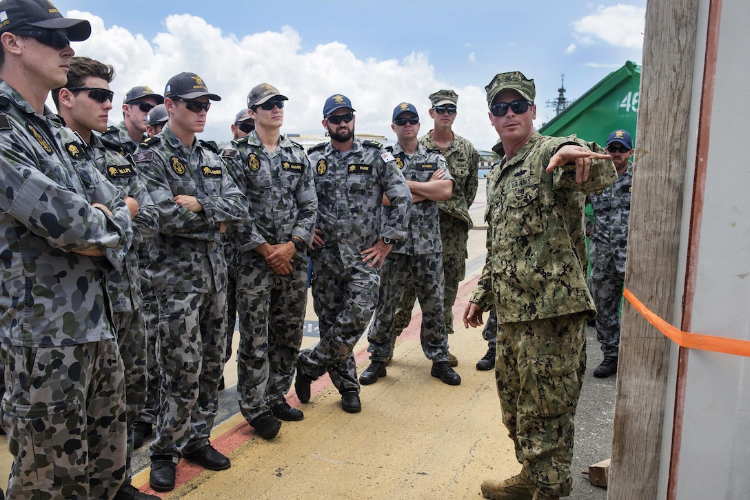 Navy Petty Officer 1st Class James Aldridge, right, explains pile wraps to Australian Clearance Diving Team 1 during a pier maintenance training mission as part of Rim of the Pacific 2016 at Joint Base Pearl Harbor-Hickam, Hawaii, July 12, 2016. Aldridge is a hospital corpsman assigned to Underwater Construction Team 2, which led the training mission. Navy photo by Petty Officer 1st Class Charles E. White