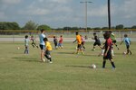 Jamie Best (left), soccer coach, runs camp participants through a series of exercises during a soccer camp July 13, 2016 at Joint Base San Antonio-Randolph. Three young coaches from England and Ireland brought their expertise and communication skills to Challenger Sports’ British Soccer Camp, which attracted more than 30 boys and girls ranging in age from 6 to 14 to Ebbets Field, one of the youth baseball diamonds on 5th Street East.