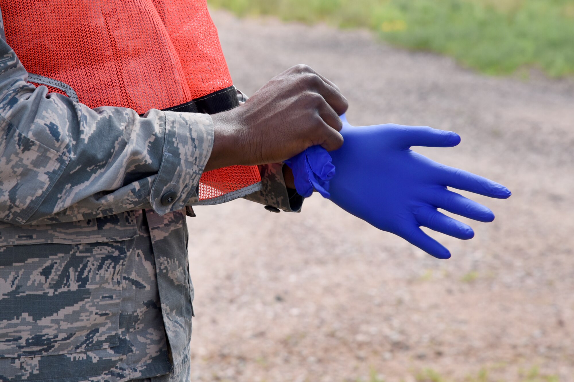 A 21st Force Support Squadron Airman puts on gloves for a search and recovery exercise at Peterson Air Force Base, Colo., July 14, 2016. The training exercise consisted of FSS Airmen and officers from Peterson AFB, Schriever AFB and representatives from the El Paso County Coroner’s Office. (U.S. Air Force photo by Airman 1st Class Dennis Hoffman)