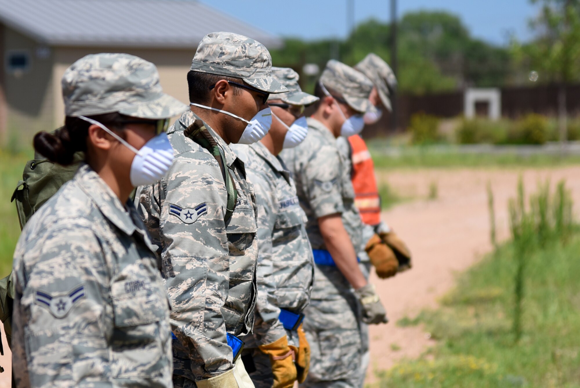 21st Force Support Squadron Airmen align themselves in a row during a search and recovery exercise at Peterson Air Force Base, Colo., July 14, 2016. Outfitted with personal protective equipment, FSS Airmen searched a training area for simulated remains and personal belongings. (U.S. Air Force photo by Airman 1st Class Dennis Hoffman)