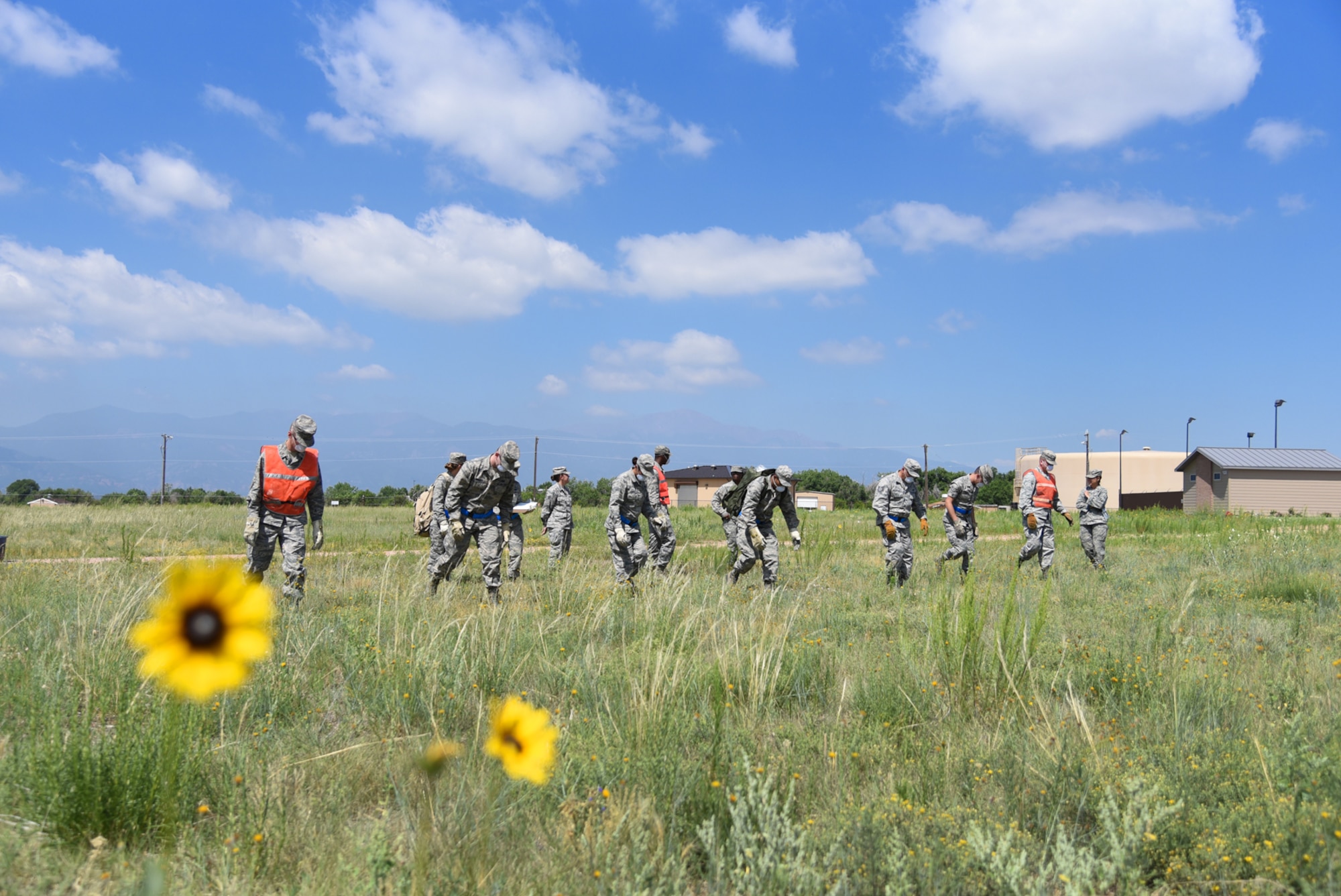 21st and 50th Force Support Squadron Airmen march forward one step at a time during a search and recovery exercise at Peterson Air Force Base, Colo., July 14, 2016. FSS Airmen made sure to identify any items or simulated remains that were within their zone during the search. (U.S. Air Force photo by Airman 1st Class Dennis Hoffman)