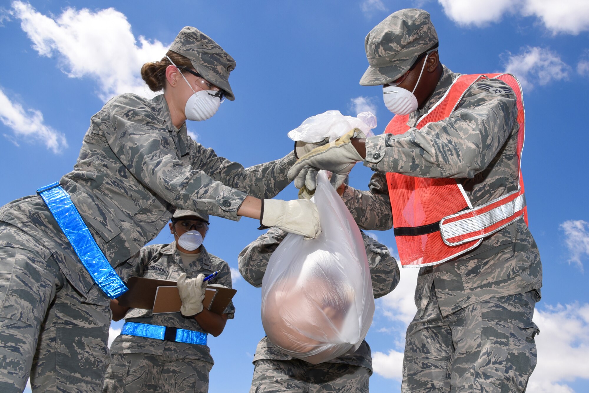 21st and 50th Force Support Squadron Airmen bag, tag and record a mock body part during a search and recovery exercise at Peterson Air Force Base, Colo., July 14, 2016. The search halted when an item was found to make sure all of the simulated remains and personal belongings were properly recorded. (U.S. Air Force photo by Airman 1st Class Dennis Hoffman)