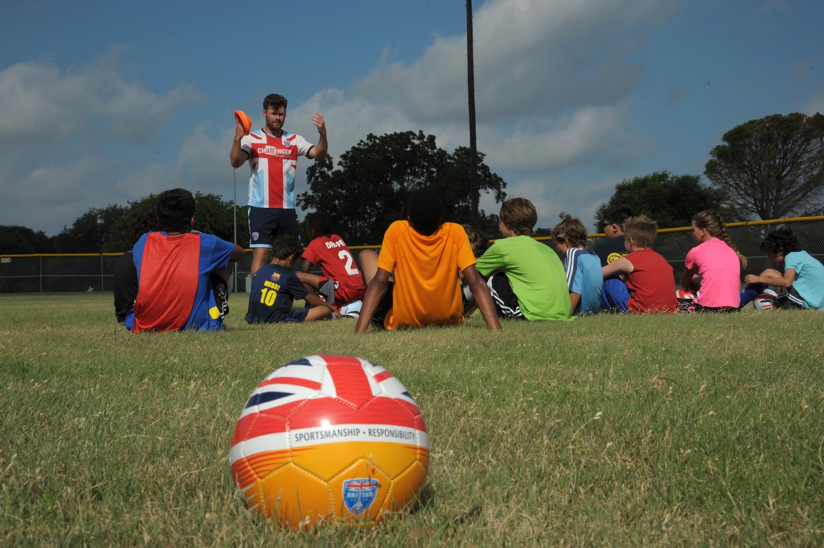 Jamie Best (left), soccer coach, runs camp participants through a series of exercises during a soccer camp July 13, 2016 at Joint Base San Antonio-Randolph. Three young coaches from England and Ireland brought their expertise and communication skills to Challenger Sports’ British Soccer Camp, which attracted more than 30 boys and girls ranging in age from 6 to 14 to Ebbets Field, one of the youth baseball diamonds on 5th Street East.