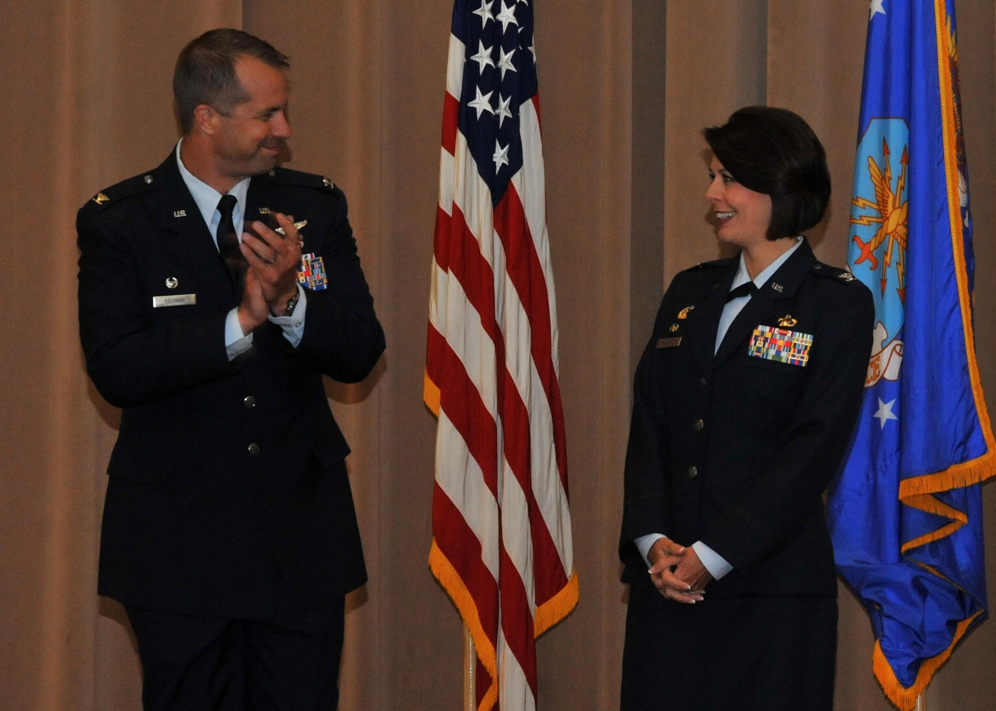 Col. Ty Neuman, 2nd Bomb Wing commander, applauds Col. DeDe Halfhill upon her assumption of command of the 2nd Mission Support Group during a change of command ceremony at Barksdale Air Force Base, La., July 19, 2016. Halfhill succeeds Col. Craig Harding, who will assume command of Pacific Air Forces Financial Management at Hickam Air Force Base, Hawaii. (U.S. Air Force photo/Senior Airman Joseph Raatz)