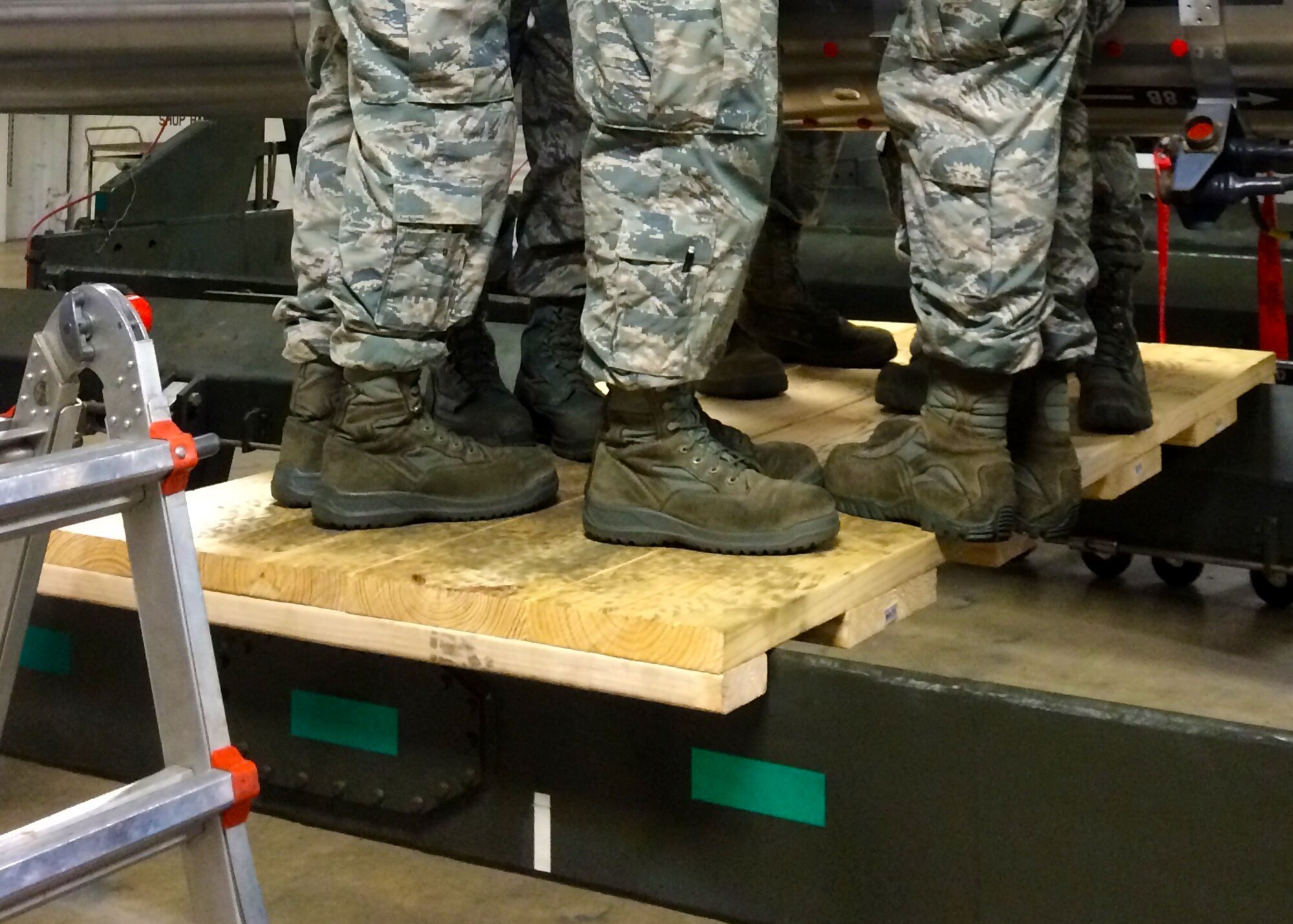 Seven Airmen conduct a weight-check of a platform designed and built by Staff Sgt. Daniel Babis, 2nd Munitions Squadron armament team chief, at Barksdale Air Force Base, La., March 18, 2016. The platform was created to address safety concerns by Airmen installing components on common rotary launchers, who previously had been forced to use step stools as they lifted 140 pound equipment up to the launcher. The platform has been tested to withstand up to 1250 pounds. (U.S. Air Force Courtesy photo)
