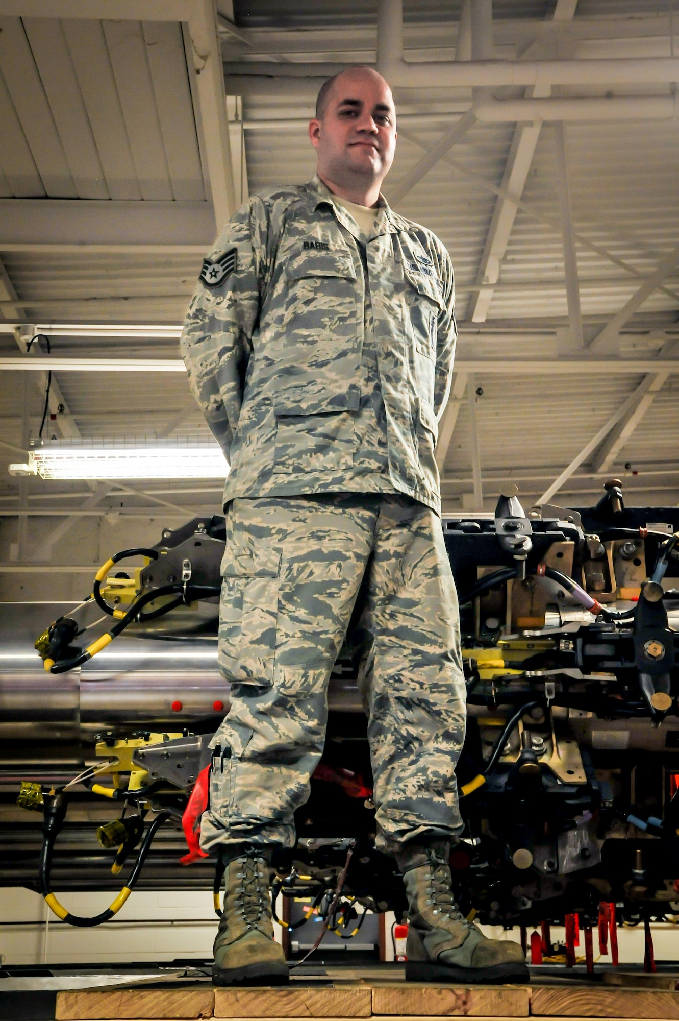 Staff Sgt. Daniel Babis, 2nd Munitions Squadron armament team chief, stands atop his innovative wooden platform at Barksdale Air Force Base, La., July 12, 2016. The platform provides a stable surface for armaments Airmen while installing components on a common rotary launcher. (U.S. Air Force photo/Senior Airman Joseph Raatz)