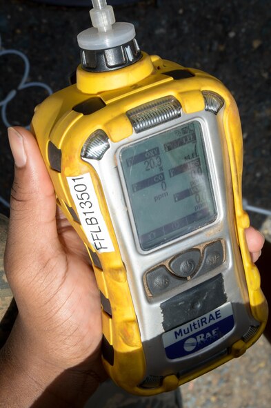 Airman 1st Class Edward Washington, 2nd Communications Squadron cable and antenna maintenance, uses a gas detector to monitor gas levels in an underground manhole system at Barksdale Air Force Base, La., July 12, 2016. While his team members inside the manhole feed cable through pathways, Washington makes sure the working environment remains safe for his team. (U.S. Air Force photo/Senior Airman Curt Beach)