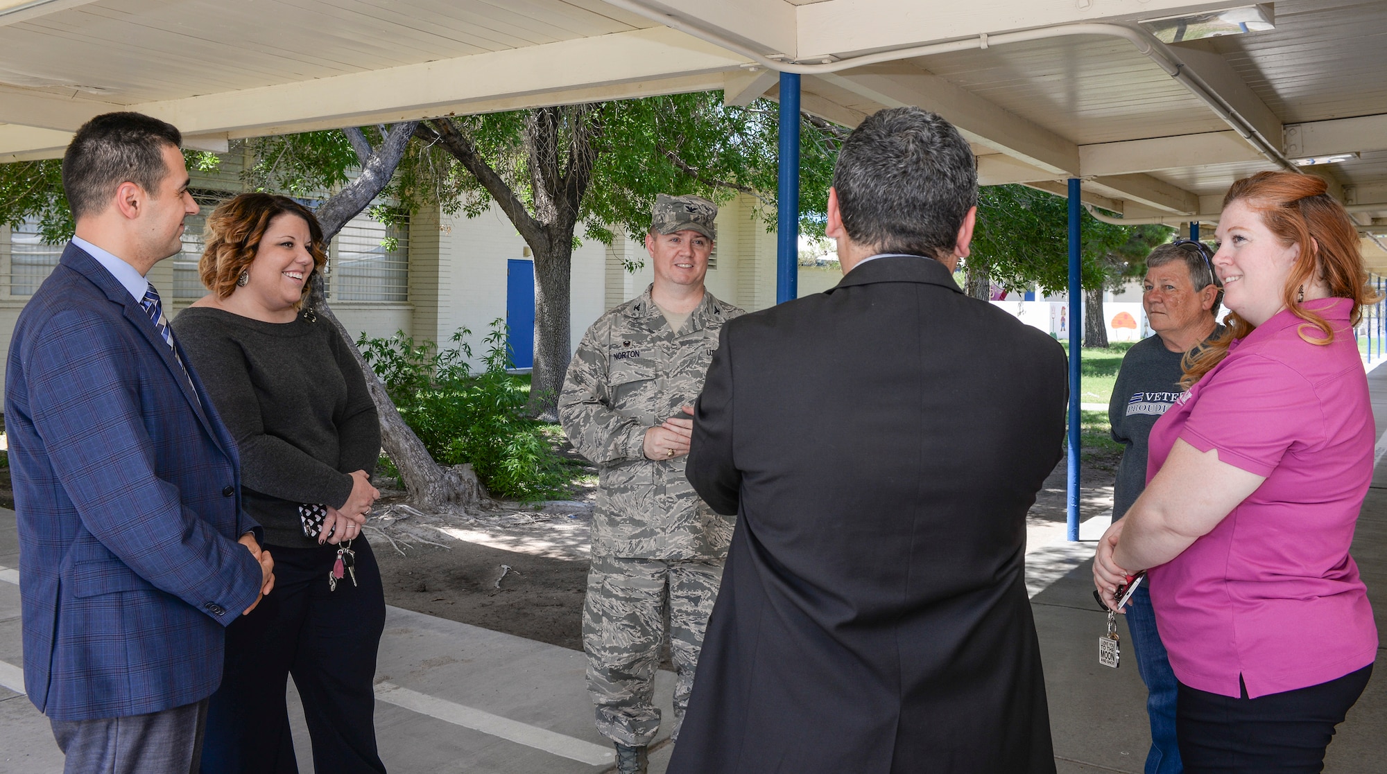 Col. William Norton, 99th Mission Support Group commander, speaks with Coral Academy of Science Las Vegas (CASLV) representatives before handing them the keys to the building July 1, 2016. The school, formerly Clark County School District-based Lomie G. Heard Elementary School, was transitioned to CASLV and will begin the academic school year Aug. 22. (U.S. Air Force photo by Senior Airman Kristin High/Released) 