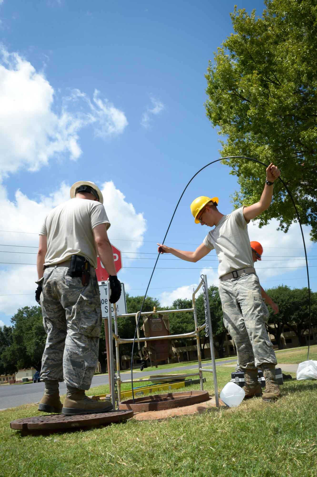 Airmen from the 2nd Communications Squadron feed fiber optic cable though an underground manhole system at Barksdale Air Force Base, La., July 12, 2016. Airmen from 2nd CS cable antenna maintenance are responsible for maintaining all physical and fiber optic structures, including more than 90,000 miles of cable on base. (U.S. Air Force photo/Senior Airman Curt Beach)
