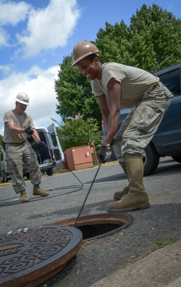 Senior Airman Aaron Griffin, foreground, and Tech. Sgt. John Hines, 2nd Communications Squadron cable and antenna maintenance, pull a fiber optic cable through an underground manhole system at Barksdale Air Force Base, La., July 12, 2016. The 2nd CS was upgrading the youth center from its copper phone line to fiber optic cable, which has 900 times the capacity of the copper, essentially an upgrade from dial-up internet to high-speed. (U.S. Air Force photo/Senior Airman Curt Beach)