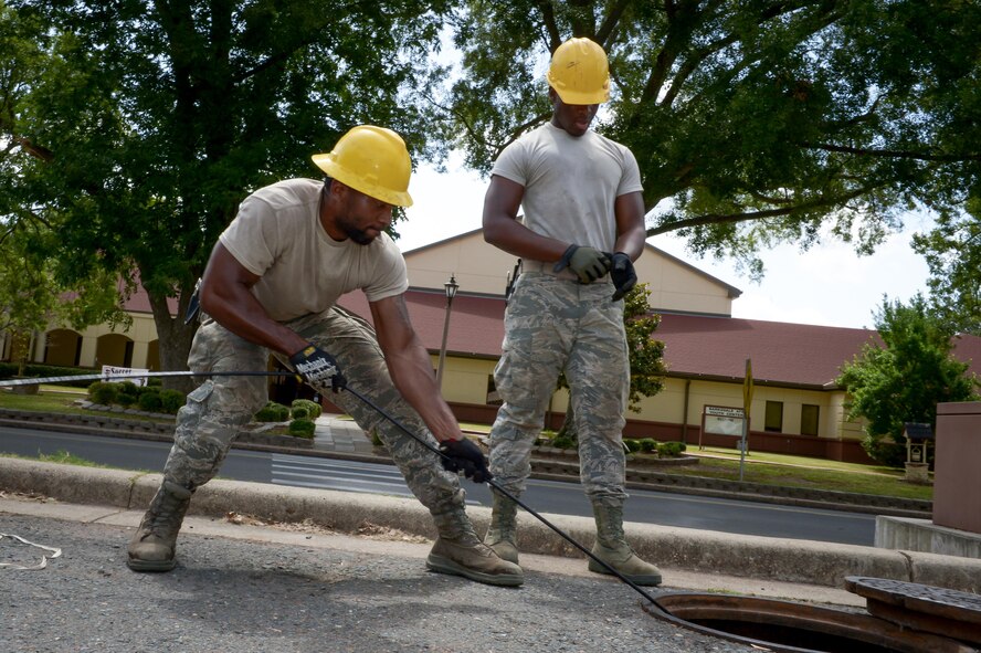 Senior Airman Leonard Tennart, 2nd Communications Squadron cable and antenna maintenance, pulls a fiber optic cable through an underground manhole system at Barksdale Air Force Base, La., July 12, 2016. Airmen from 2nd CS cable antenna maintenance are responsible for maintaining all physical and fiber optic structures, including more than 90,000 miles of cable on base. (U.S. Air Force photo/Senior Airman Curt Beach)