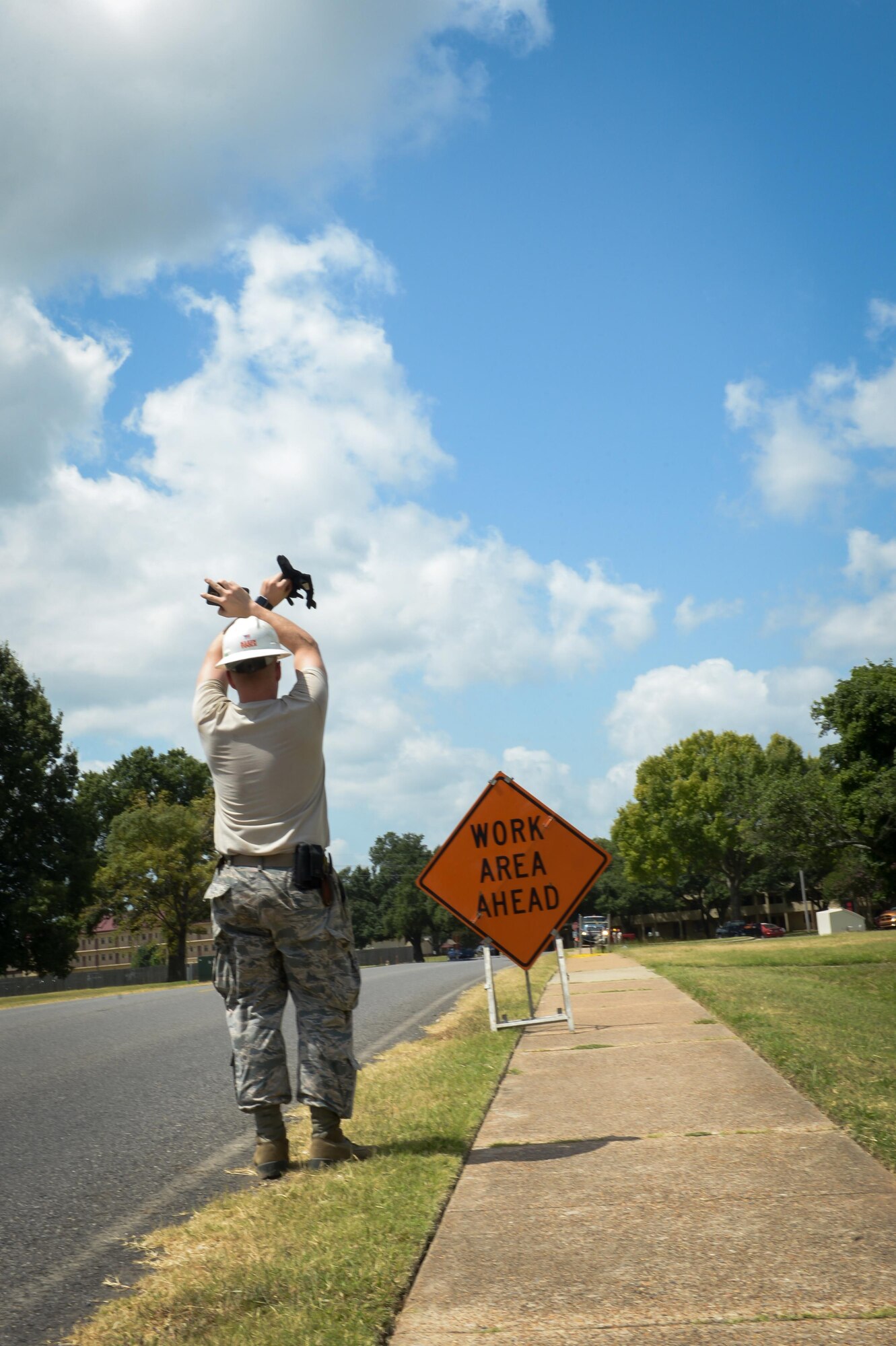 Tech. Sgt. John Hines, 2nd Communications Squadron cable and antenna maintenance, signals to his team to stop feeding cable though an underground manhole system at Barksdale Air Force Base, La., July 12, 2016. By installing and maintaining fiber optics, copper and coaxial lines, cable and antenna systems specialists, also known as cable dawgs, ensure the installation has efficient means of communication required to accomplish mission needs. (U.S. Air Force photo/Senior Airman Curt Beach)