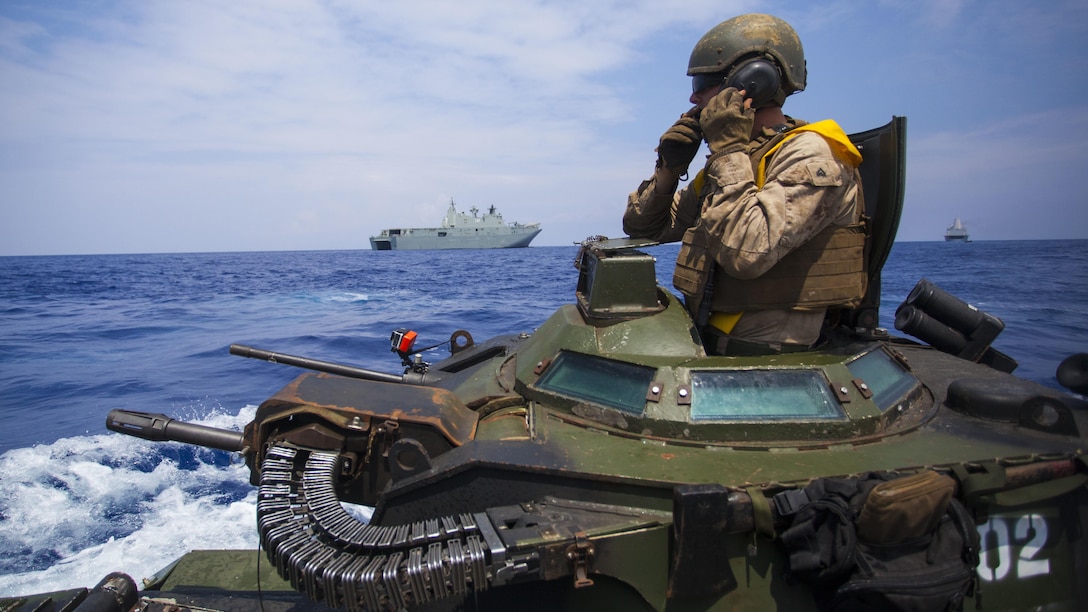 Cpl. Ryan Dills communicates with other assault amphibious vehicles while traveling from amphibious assault ship USS San Diego to Royal Australian Navy Canberra class amphibious ship HMAS Canberra in the Pacific Ocean, July, 18 2016. The Marines are participating in the Rim of the Pacific 2016, a multinational military exercise, from June 29 to Aug. 4 in and around the Hawaiian Islands.