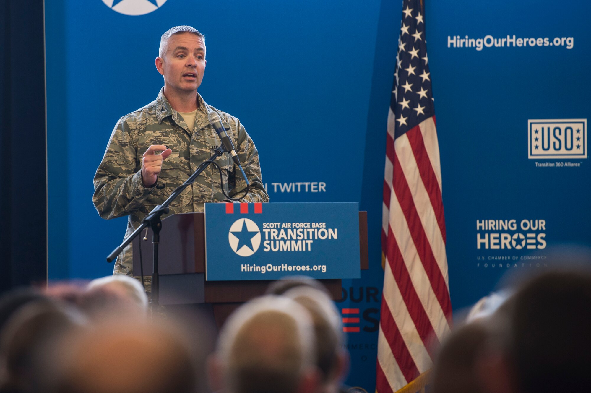 Col. Chris Buschur, 375th Air Mobility Wing vice commander, speaks during a two-day transition summit and hiring and education fair for transitioning members, veterans, and spouses, Scott Air Force Base, Ill., July 12, 2016.  The first day of the transition summit offered industry briefs from Microsoft, the 375th Communications Group, Alcoa, Fastport, and SSM Health to transitioning service members, veterans, and military spouses, followed by a panel discussion with senior leaders of potential employers that answered questions of audience members on the transitioning process. The second day featured employment workshops, another panel discussion on different transition perspectives, and a hiring and education fair.   (U.S. Air Force photo by Staff Sgt. Jodi Martinez/Released)